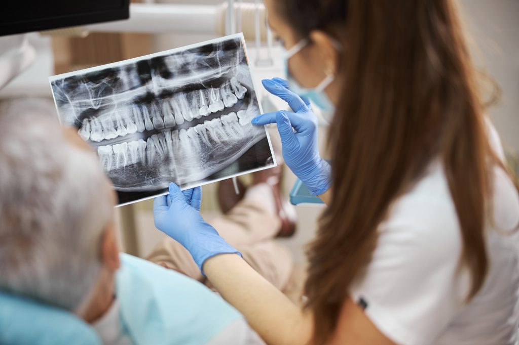 Young dental specialist holding a dental x-ray image